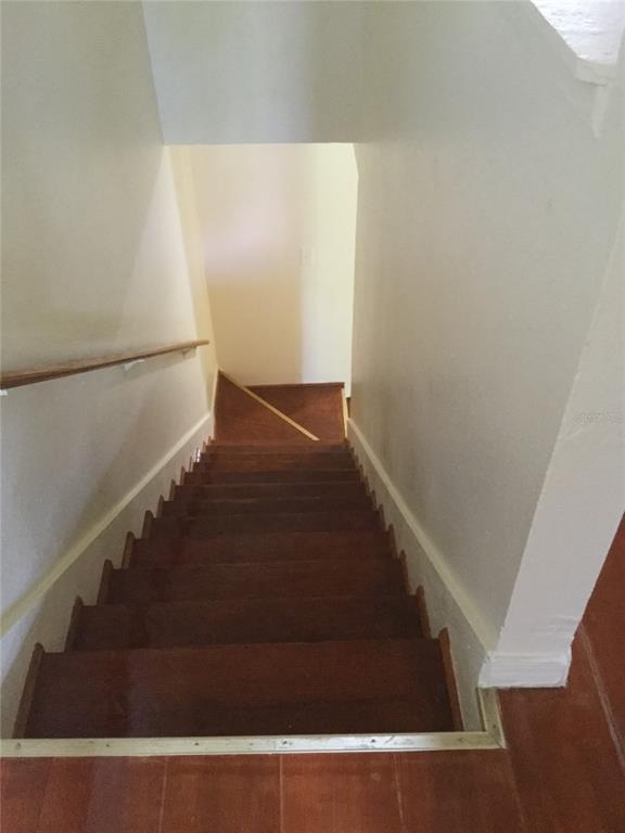 A view looking down a set of wooden stairs with a handrail toward a landing — 2454 RIO PINAR LAKES BOULEVARD, ORLANDO, FL