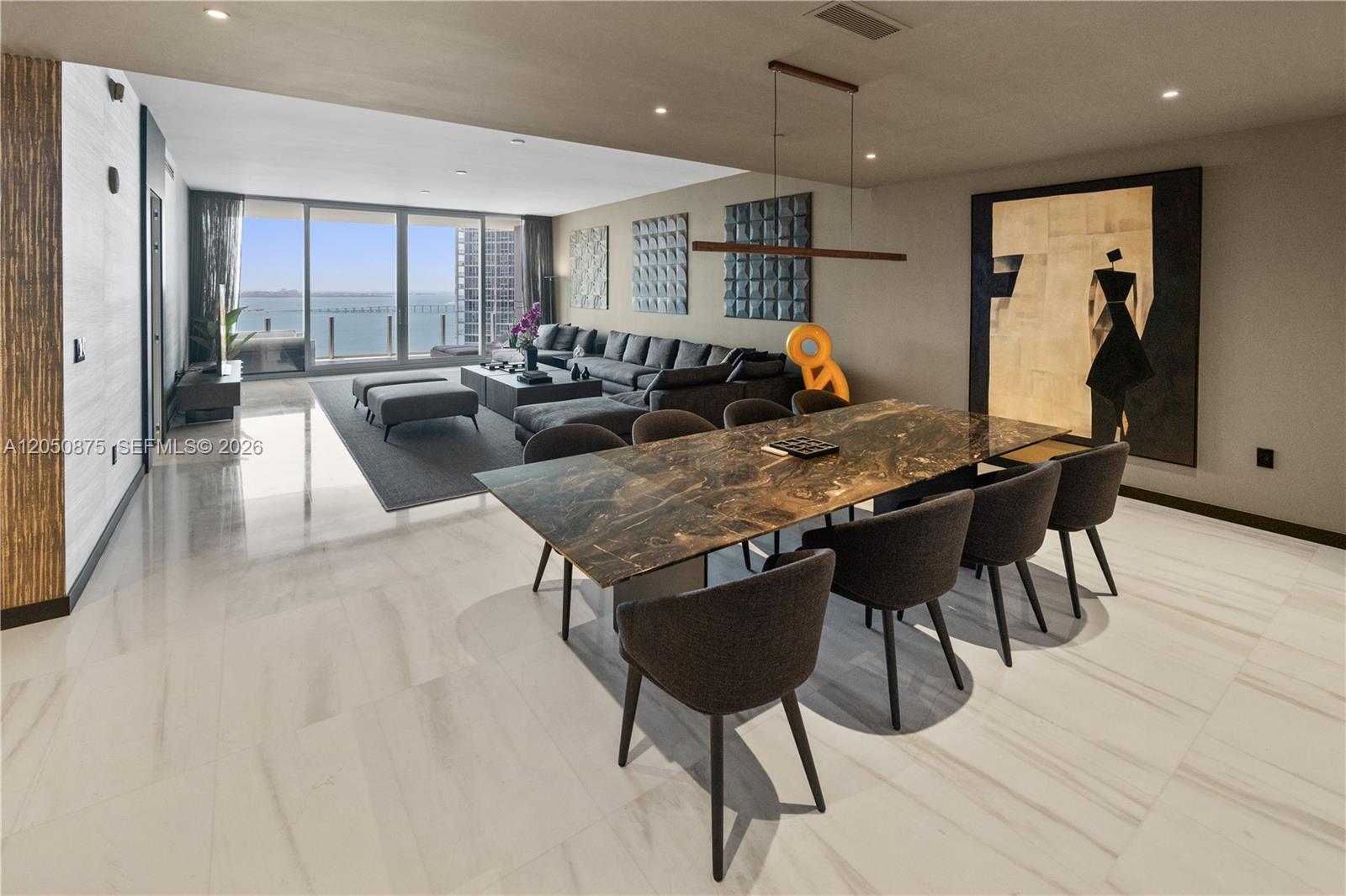 A modern open-plan living and dining area features marble floors, a dark stone table, and floor-to-ceiling windows — 300 Biscayne Blvd Way # 3104, Miami FL 33131, MIAMI, FL