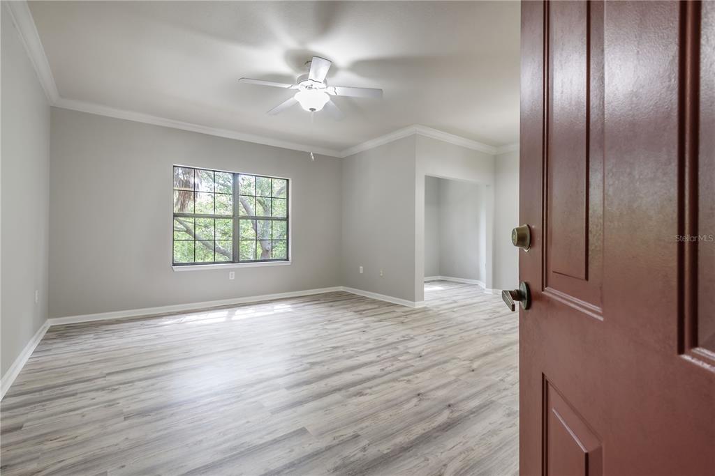 A room with light gray walls, wood-look flooring, a ceiling fan, and a window — 2262 CHIANTI PLACE UNIT 5-0526, PALM HARBOR, FL