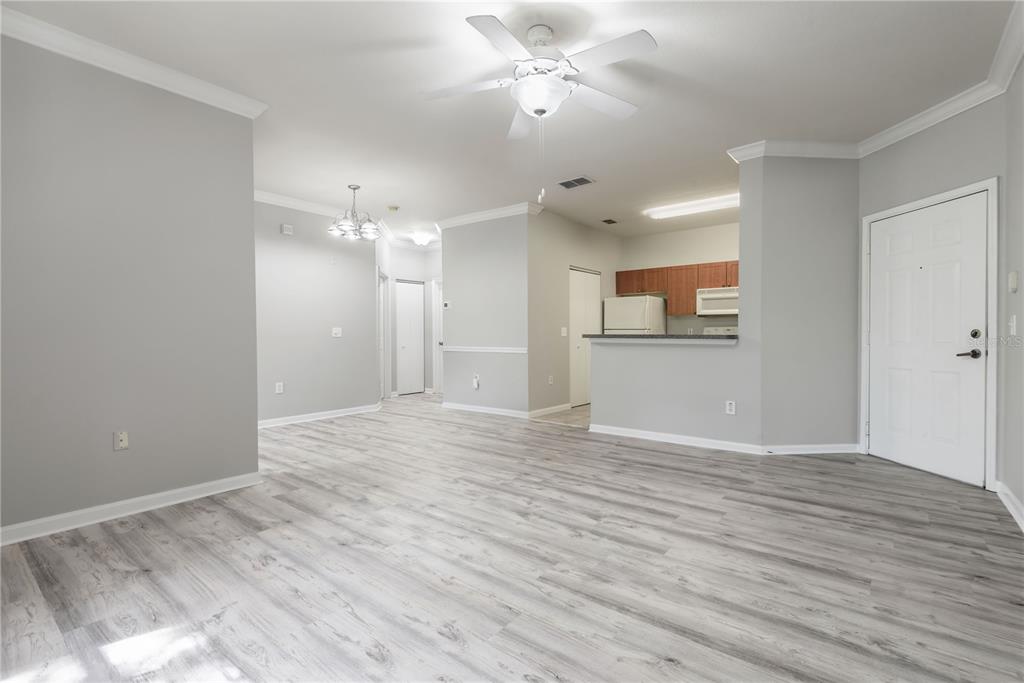 An open-concept living area features light gray walls, wood-look flooring, and a kitchen pass-through — 2262 CHIANTI PLACE UNIT 5-0526, PALM HARBOR, FL