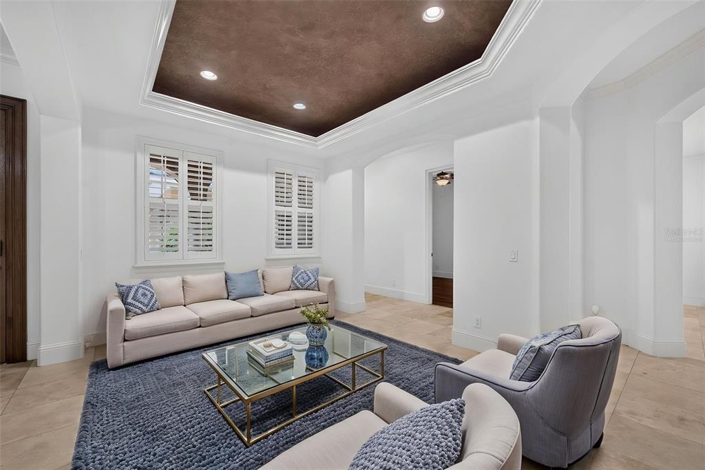 A living room features a dark tray ceiling, white walls, tile floors, and a blue rug — 341 E READING WAY, WINTER PARK, FL