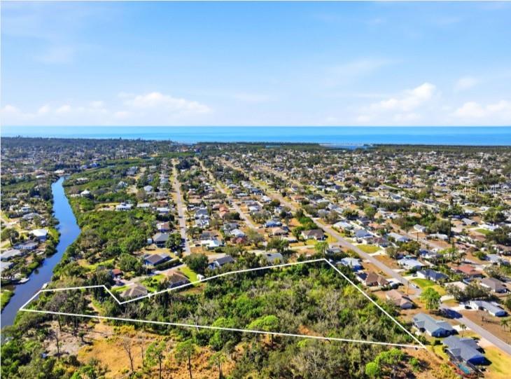 An aerial view shows a large, undeveloped lot outlined in white near a coastal neighborhood — 0 DUNBAR ROAD, VENICE, FL