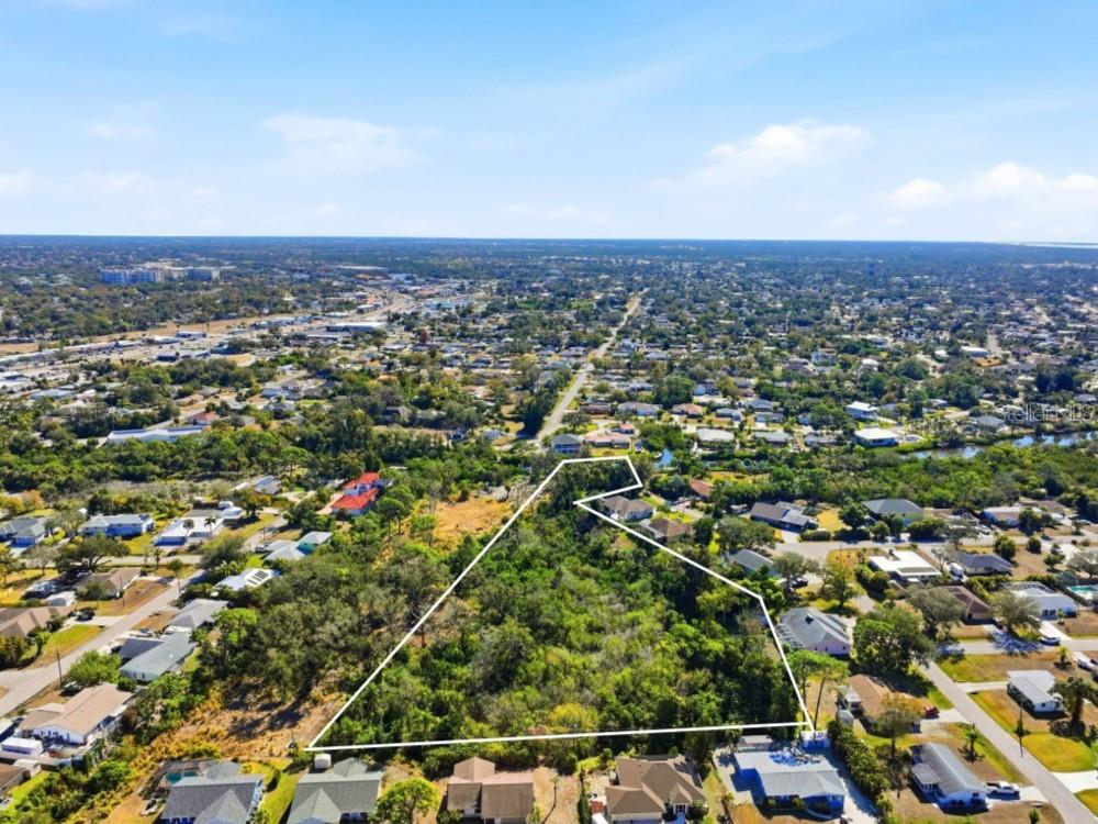 An aerial view shows a large, undeveloped, wooded lot outlined in white within a residential neighborhood — 0 DUNBAR ROAD, VENICE, FL