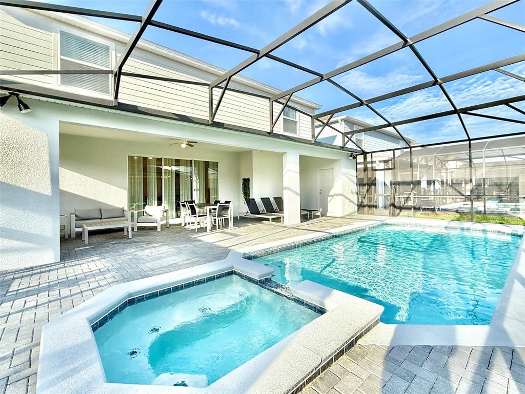A screened-in patio features a swimming pool, a hot tub, and outdoor furniture — 4453 KAIPO ROAD, DAVENPORT, FL