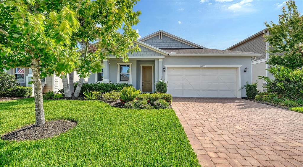 A single-story house with a paved driveway, a two-car garage, and a front lawn — 14239 59TH CIRCLE E, BRADENTON, FL