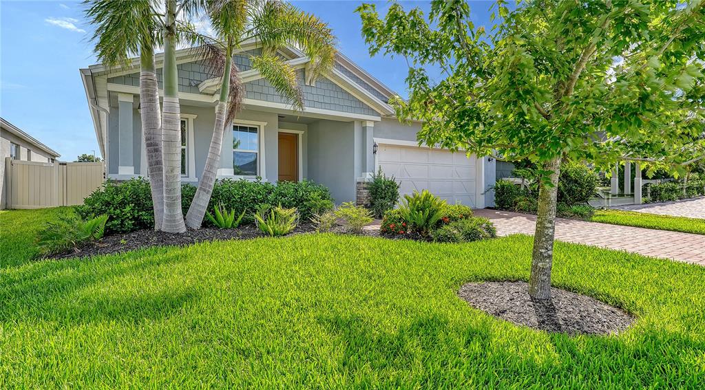 A single-story house with a gray exterior, a two-car garage, and a manicured front lawn — 14239 59TH CIRCLE E, BRADENTON, FL