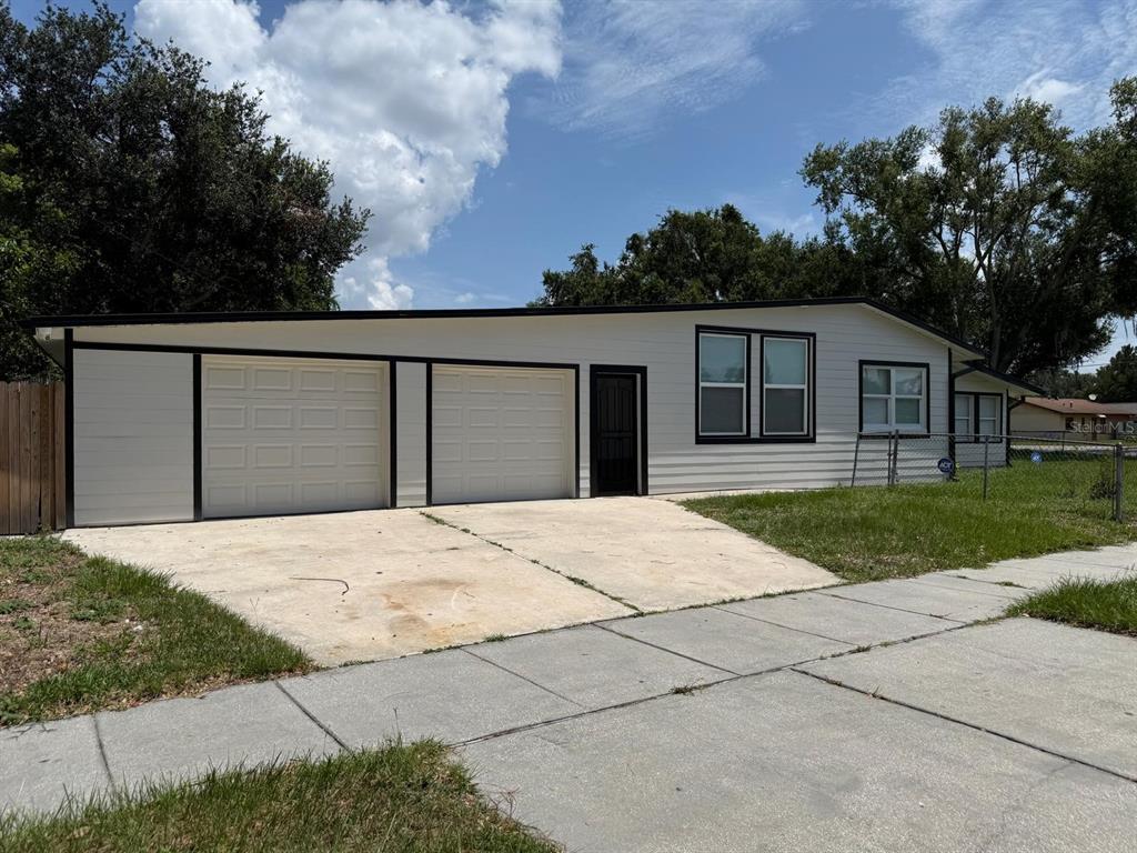 A single-story house with white siding, black trim, two garage doors, and a concrete driveway — 2352 OLD DIXIE HIGHWAY, KISSIMMEE, FL