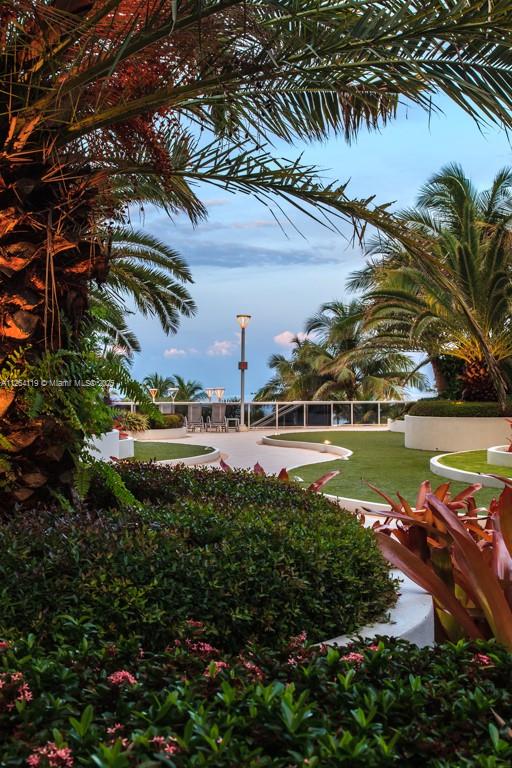 A landscaped outdoor terrace features palm trees, manicured grass, and a view of the ocean — 100 Lincoln Rd # 943, Miami Beach FL 33139, MIAMI BEACH, FL