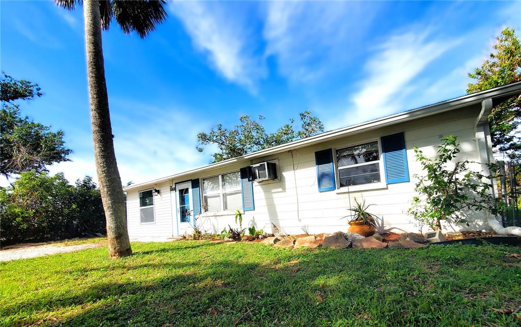 A single-story white house with blue shutters and a palm tree in the front yard — 8362 OSPREY ROAD, ENGLEWOOD, FL