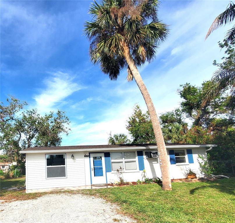 A single-story white house with blue shutters and a prominent palm tree in the yard — 8362 OSPREY ROAD, ENGLEWOOD, FL