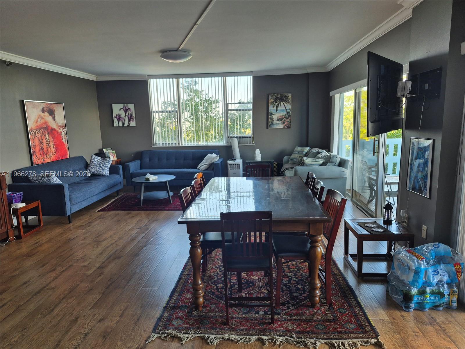A living and dining room area features dark gray walls, wood flooring, and area rugs — 4001 Hillcrest Dr # 416, Hollywood FL 33021, HOLLYWOOD, FL