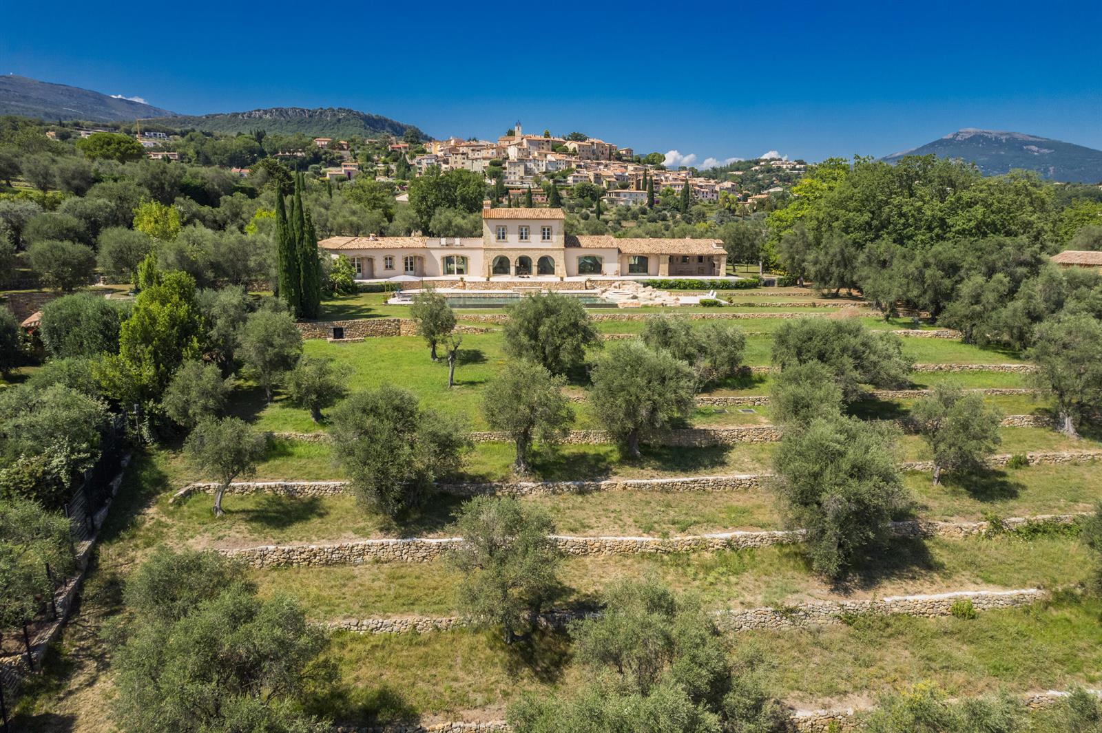 An aerial view shows a stone villa with a pool surrounded by terraced olive groves — 20 Chemin De Bellevue, FL
