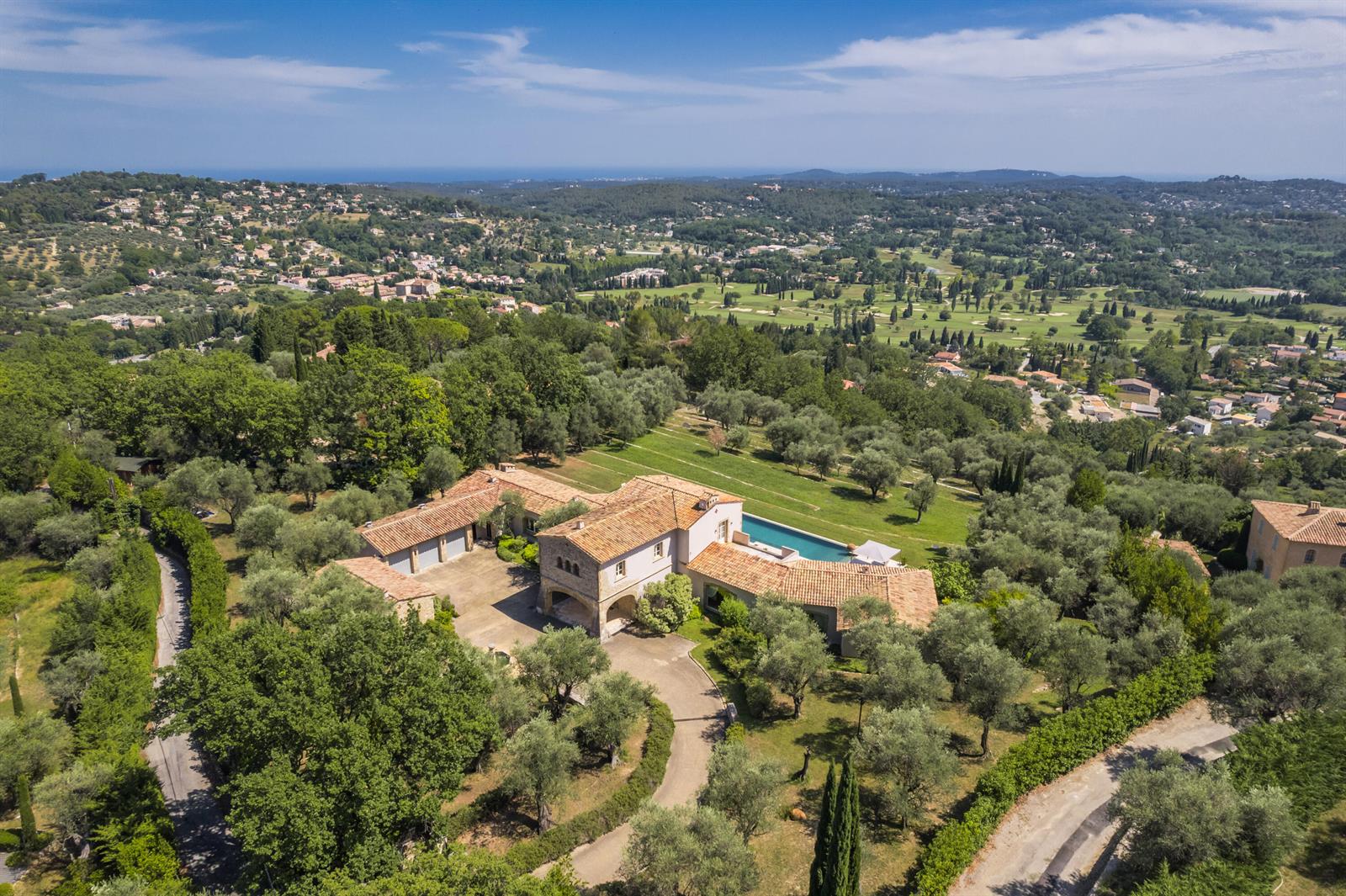 An aerial view shows a large villa with a tiled roof, pool, and surrounding trees — 20 Chemin De Bellevue, FL