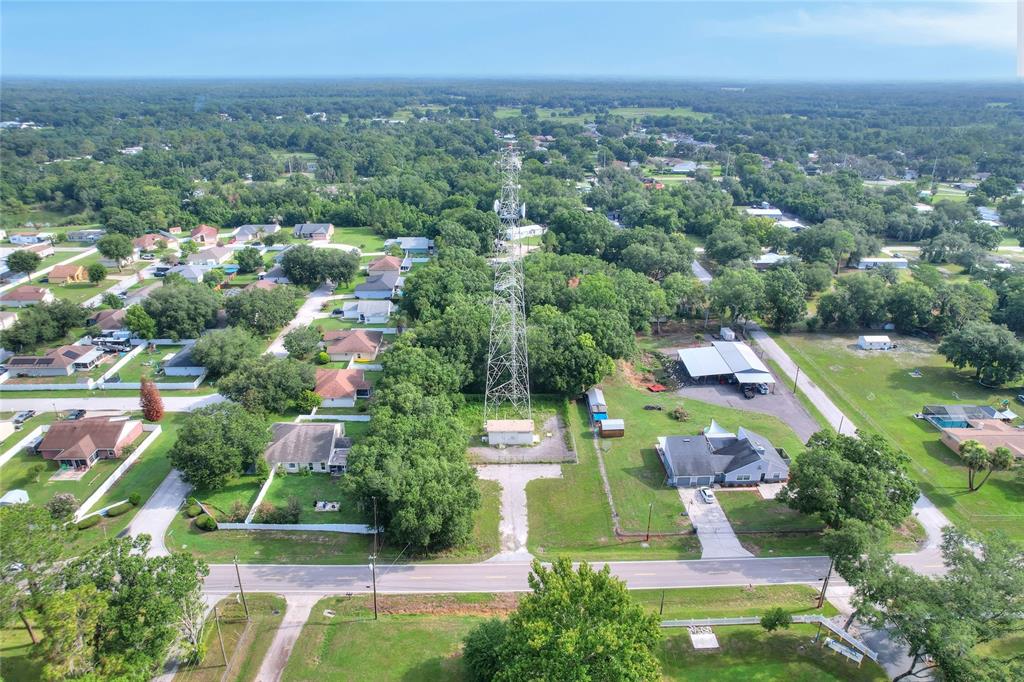 An aerial view shows a tall communication tower situated on a lot amidst residential houses — 325 WILDER ROAD, LAKELAND, FL