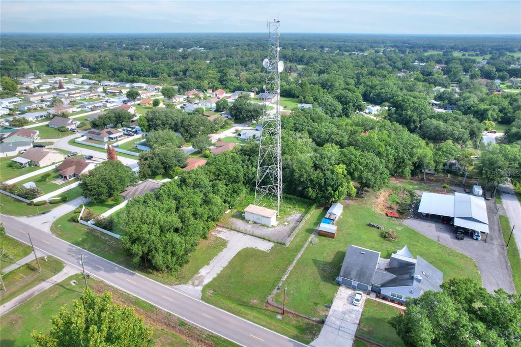 An aerial view shows a tall communication tower situated on a lot near residential homes — 325 WILDER ROAD, LAKELAND, FL