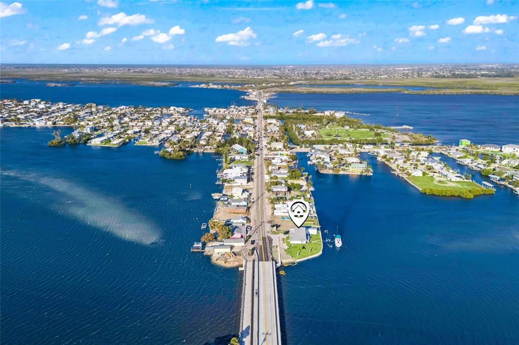 An aerial view shows a house with a location pin on a narrow coastal peninsula — 4767 PINE ISLAND ROAD NW, MATLACHA, FL