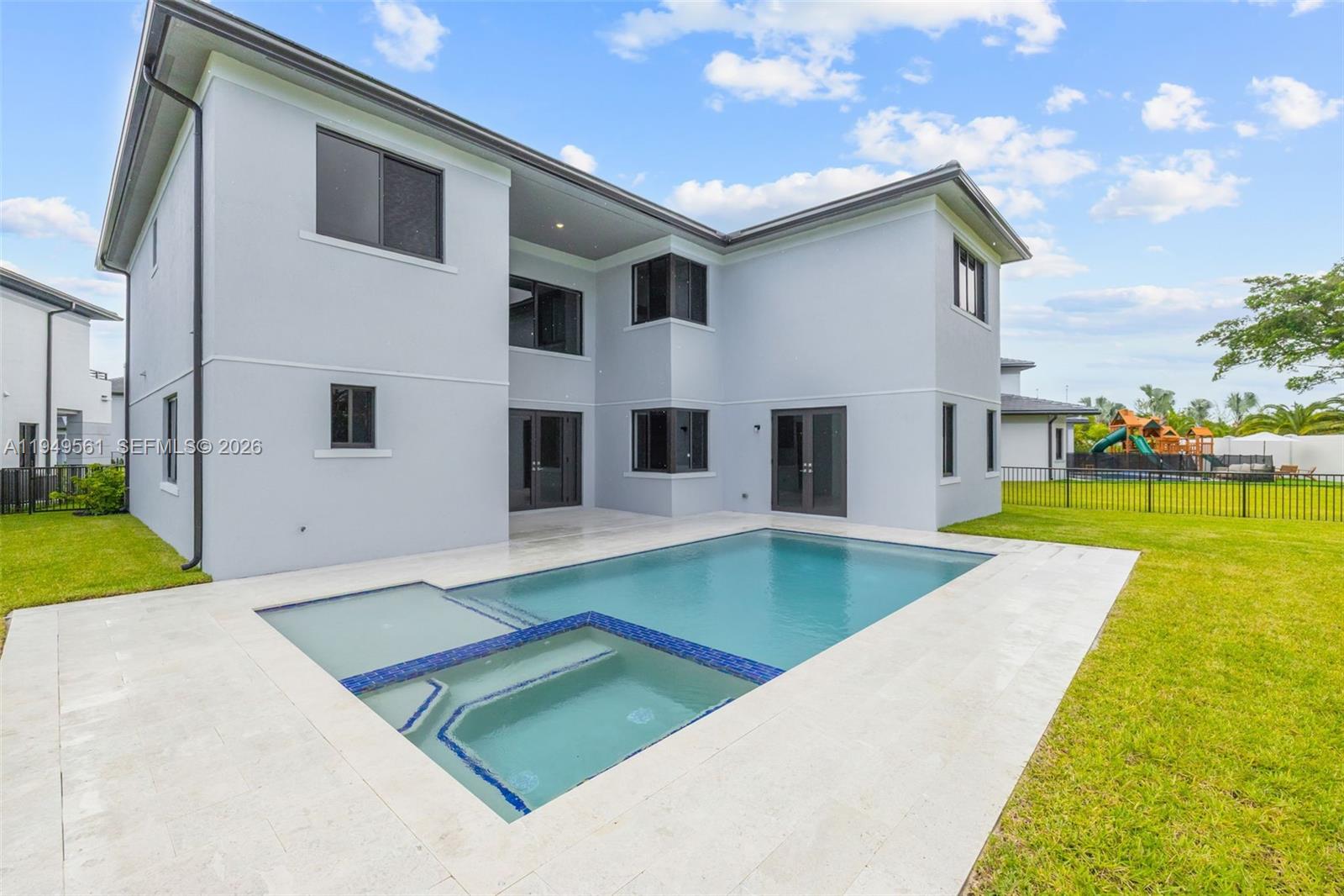 The exterior of a two-story house features a backyard with a swimming pool and lawn — 19749 NE 16th Pl # 19749, Miami FL 33179, MIAMI, FL
