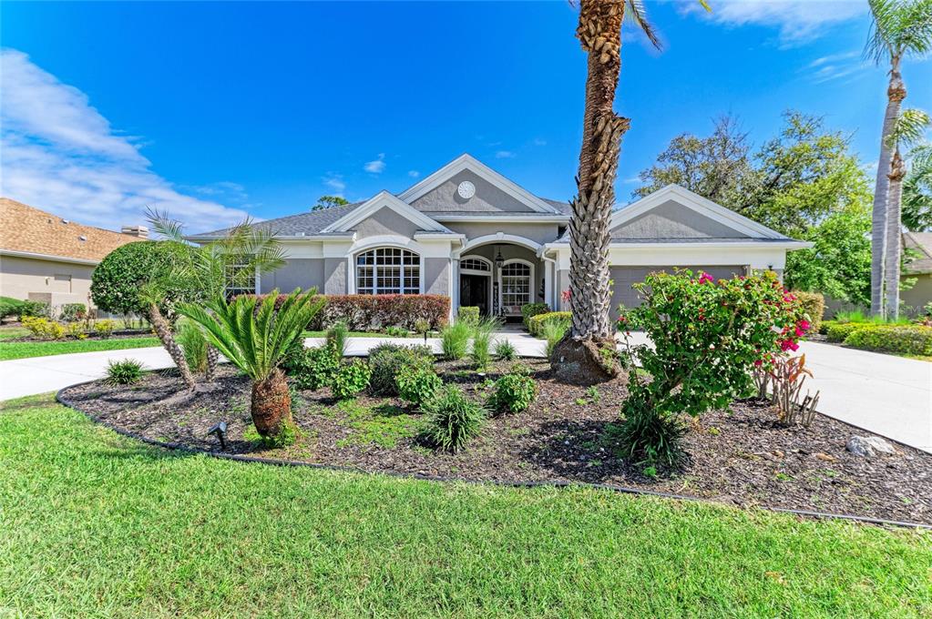 A single-story house with a gray exterior, a paved driveway, and a landscaped front yard — 2337 LITTLE COUNTRY ROAD, PARRISH, FL
