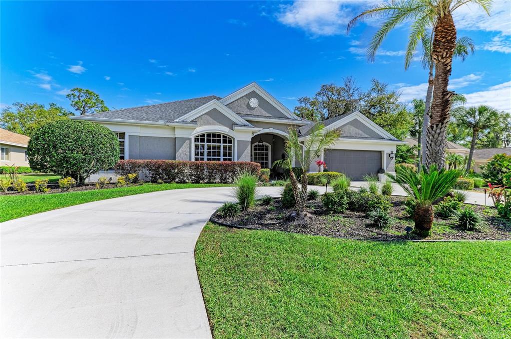 A single-story house with a gray exterior, arched window, and a curved concrete driveway — 2337 LITTLE COUNTRY ROAD, PARRISH, FL
