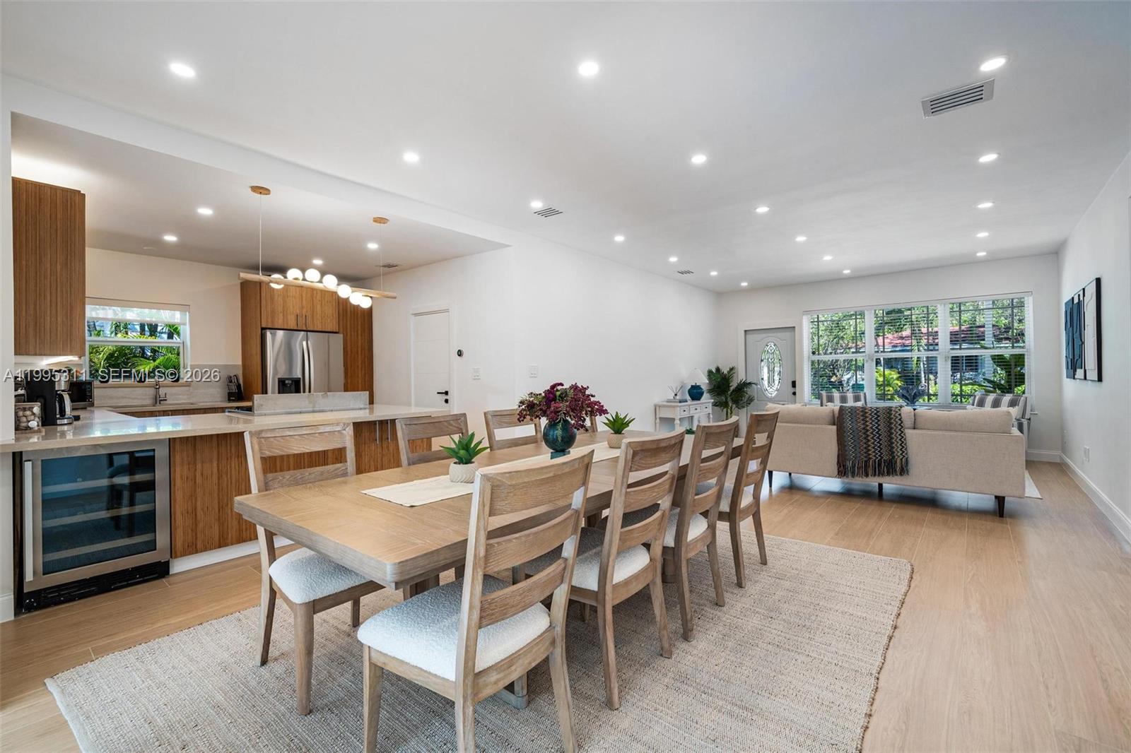 An open-concept dining area and kitchen feature light wood cabinetry, a dining table, and flooring — 696 NE 67th St, Miami FL 33138, MIAMI, FL