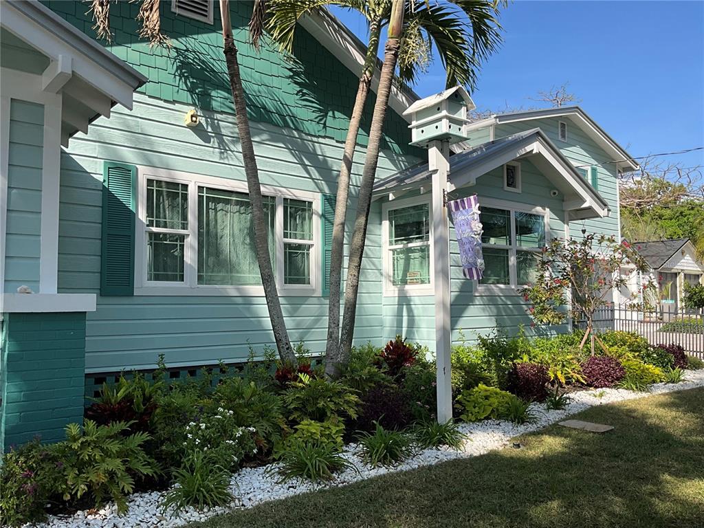 A light blue house with green shingles, white trim, and a landscaped front garden — 202 FAIRMONT STREET, CLEARWATER, FL