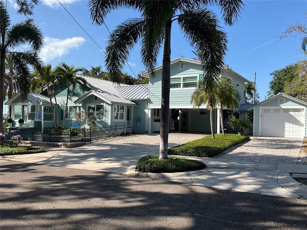 A light blue two-story house with a metal roof, palm trees, and a detached garage — 202 FAIRMONT STREET, CLEARWATER, FL