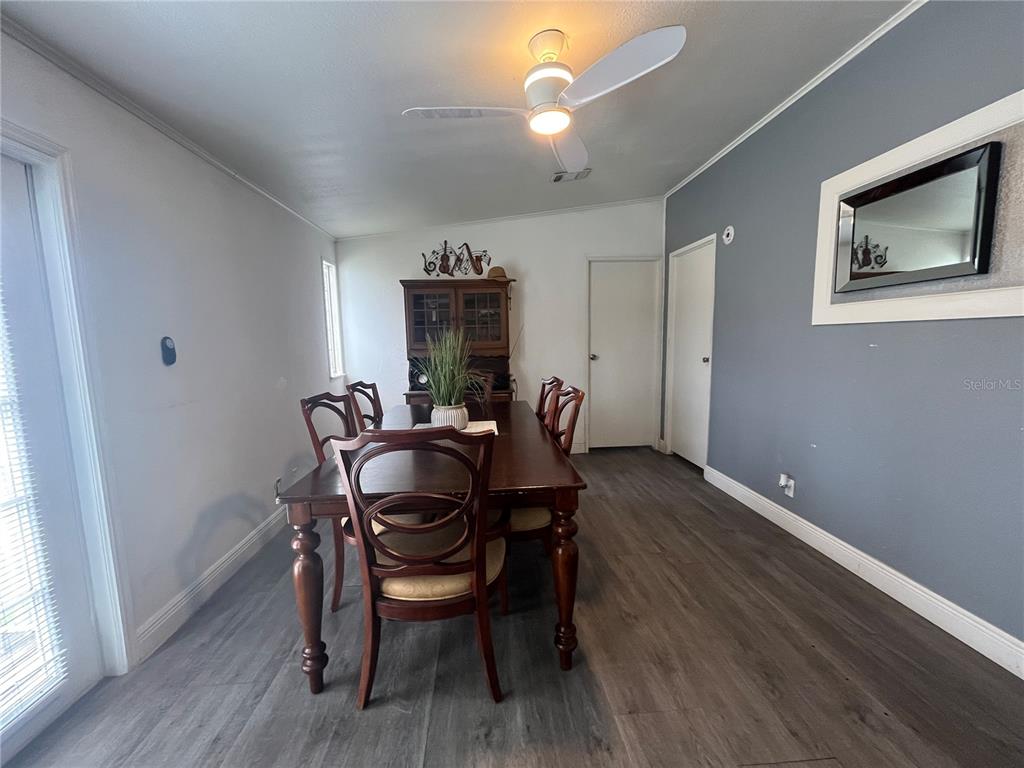 A dining room features a wooden table, six chairs, gray flooring, and a ceiling fan — 10780 STATE ROAD 60 E, LAKE WALES, FL