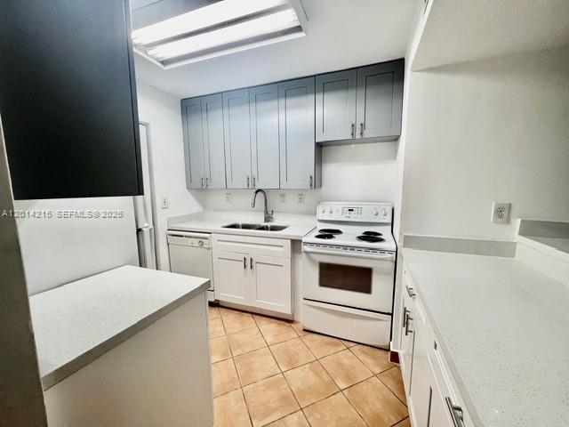 A kitchen features gray upper cabinets, white lower cabinets, white countertops, and tiled flooring — 10755 SW 108th Ave # 302, Miami FL 33176, MIAMI, FL
