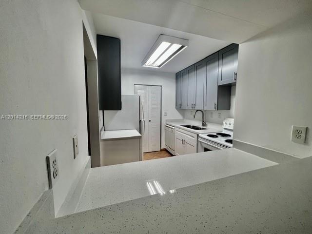A kitchen features gray cabinets, white countertops, and a white refrigerator — 10755 SW 108th Ave # 302, Miami FL 33176, MIAMI, FL