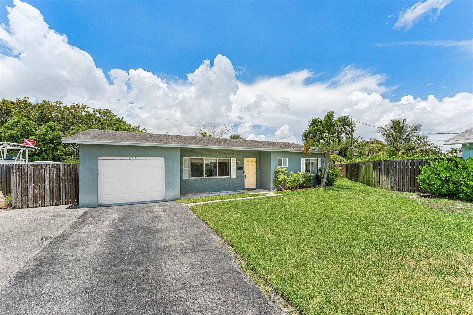 A single-story house with a gray exterior, a white garage door, and a grassy lawn — 301 SE 3rd Street, Deerfield Beach FL 33441, DEERFIELD BEACH, FL