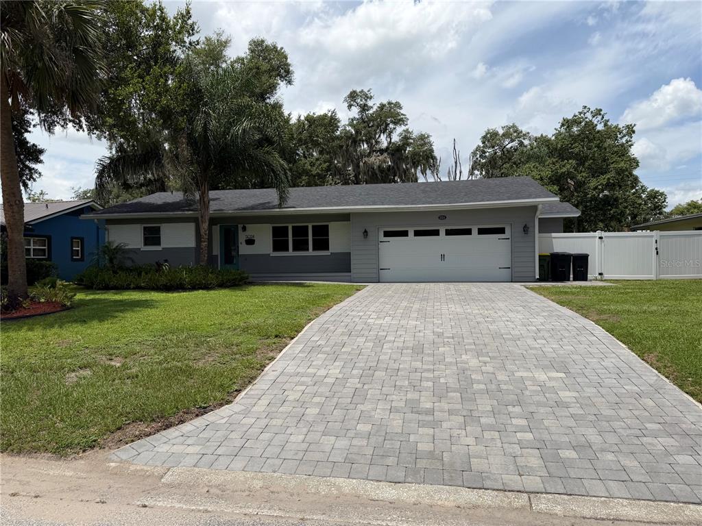 A single-story house with a gray exterior, a paved driveway, and a two-car garage — 5024 MORTIER AVENUE, ORLANDO, FL