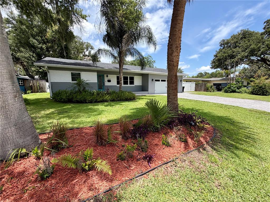 A single-story house with a white and gray exterior, a garage, and a landscaped yard — 5024 MORTIER AVENUE, ORLANDO, FL