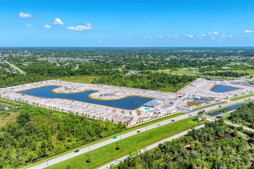 An aerial view shows a new residential development under construction with a central lake — 9001 GASPARILLA ROAD UNIT 35, PLACIDA, FL