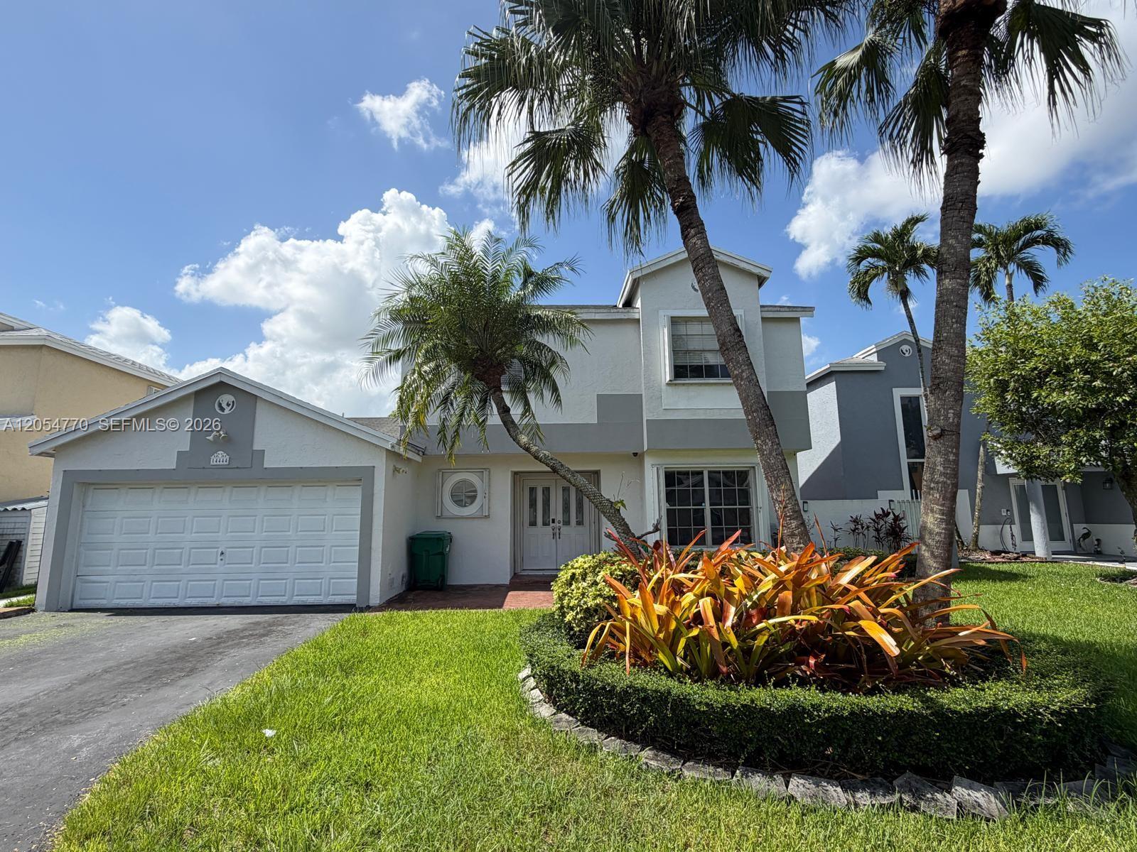 A two-story house with a white stucco facade, a garage, and palm trees in front — 14444 SW 92nd Ter # 14444, Miami FL 33186, MIAMI, FL