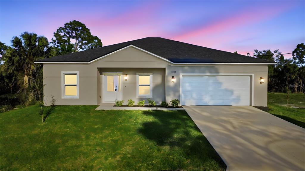 A single-story house with a beige exterior, a two-car garage, and a grassy front yard — 3227 HALSEY AVENUE SE, PALM BAY, FL
