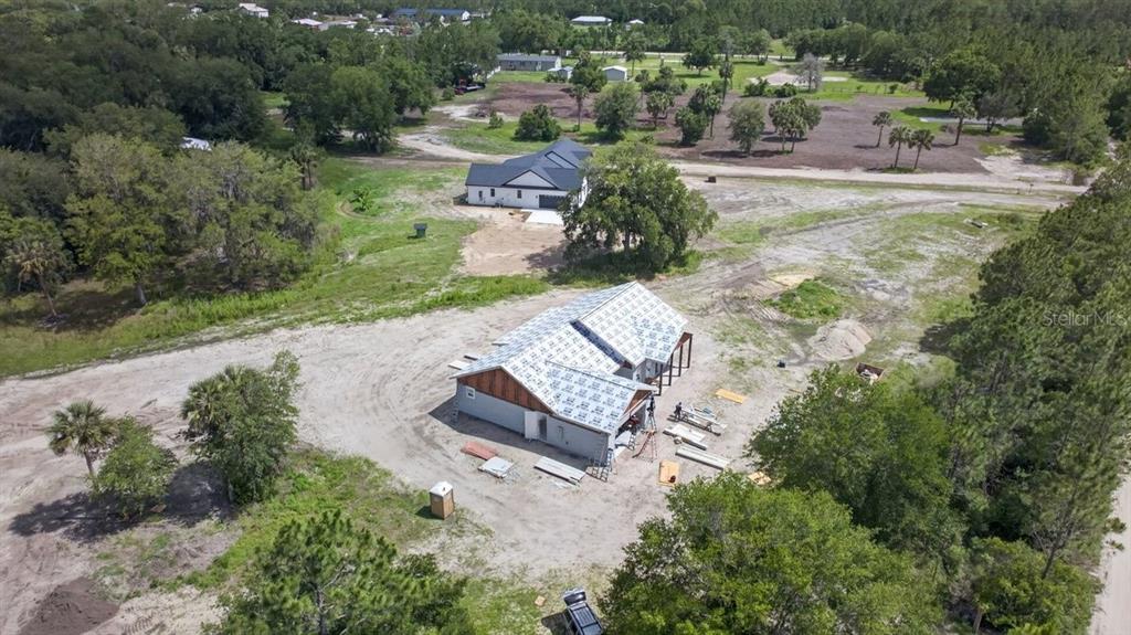 An aerial view shows a house under construction with a roof underlayment in a rural area — 31 FAVORETTA ROAD, BUNNELL, FL