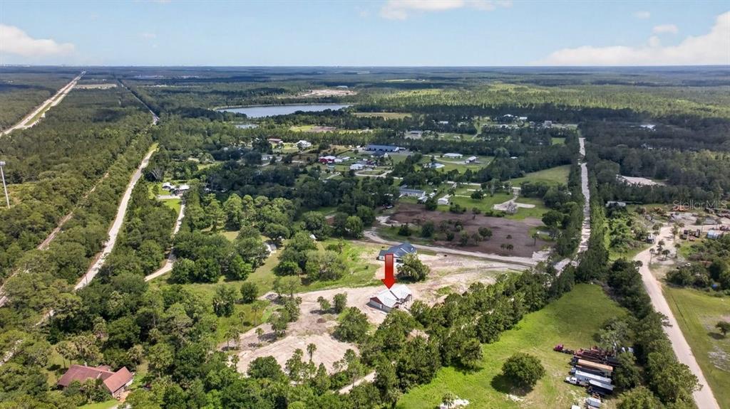 An aerial view shows a house under construction on a large, partially wooded rural lot — 31 FAVORETTA ROAD, BUNNELL, FL