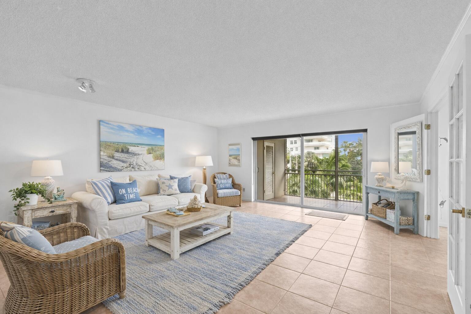 A bright living room features a white sofa, wicker chairs, a blue rug, and a balcony — 2501 S Ocean Boulevard # 3010, Boca Raton FL 33432, BOCA RATON, FL