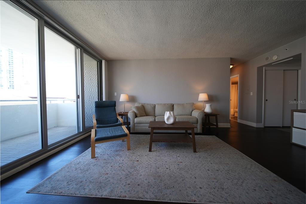 A living room features a sofa, a blue armchair, a coffee table, and a balcony — 470 3RD STREET S UNIT 612, ST PETERSBURG, FL