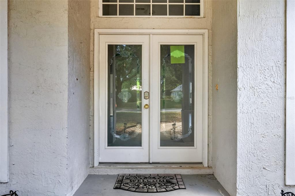 A white double front door with glass panels and a transom window above — 39914 SUNBEAM WAY, LADY LAKE, FL