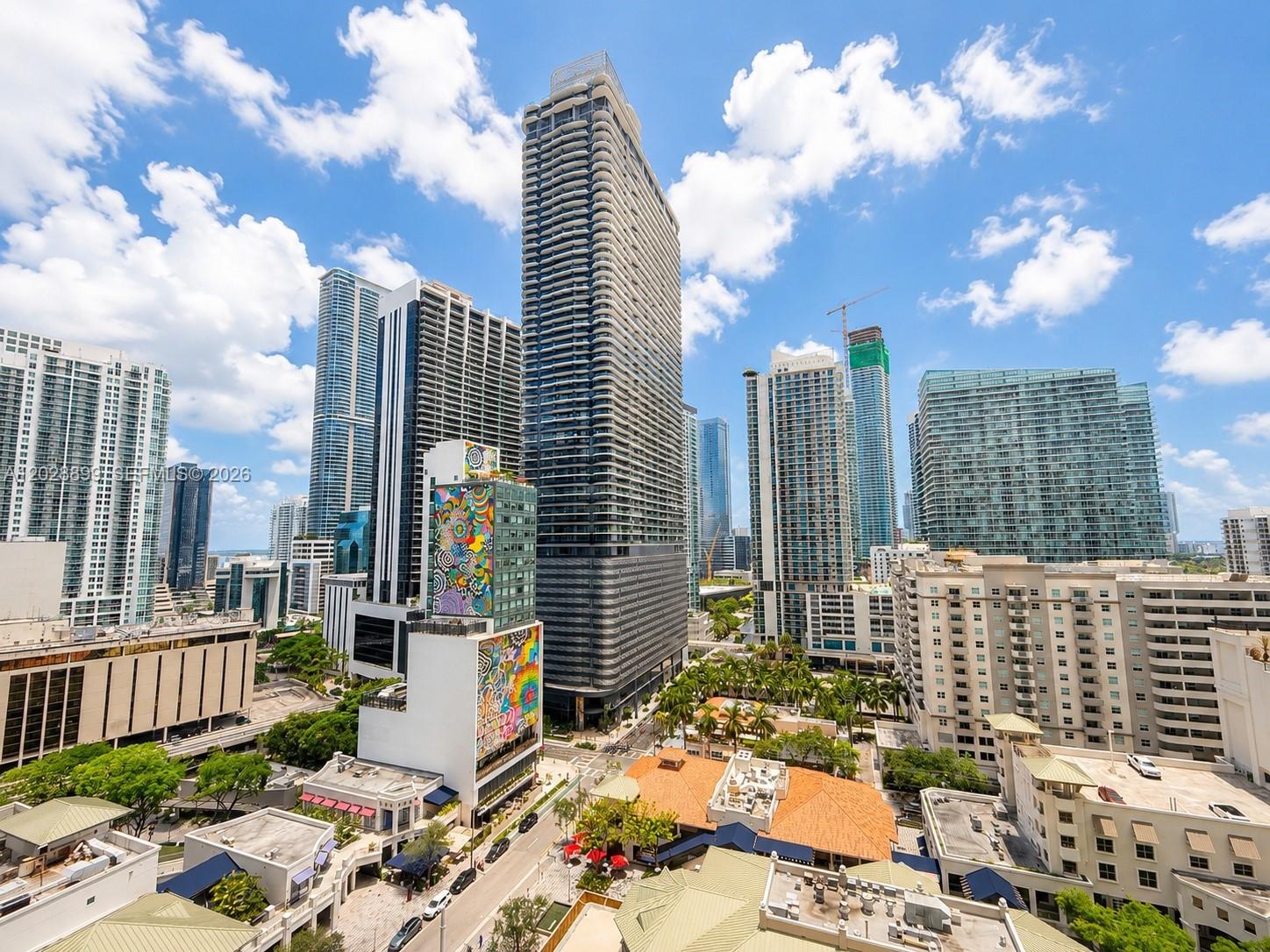 An elevated view of a dense urban skyline featuring modern skyscrapers and a colorful mural — 45 SW 9th St # 1506, Miami FL 33130, MIAMI, FL