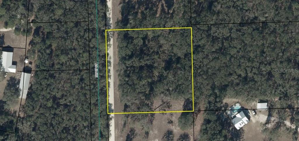 An aerial view shows a rectangular, wooded vacant lot outlined in yellow next to a road — NW 37 COURT, BRANFORD, FL