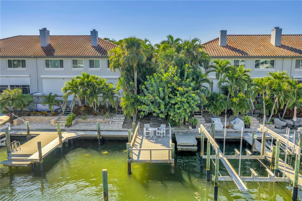 An exterior view of waterfront townhomes with private docks and lush tropical landscaping — 903 PINELLAS BAYWAY S UNIT 302, TIERRA VERDE, FL