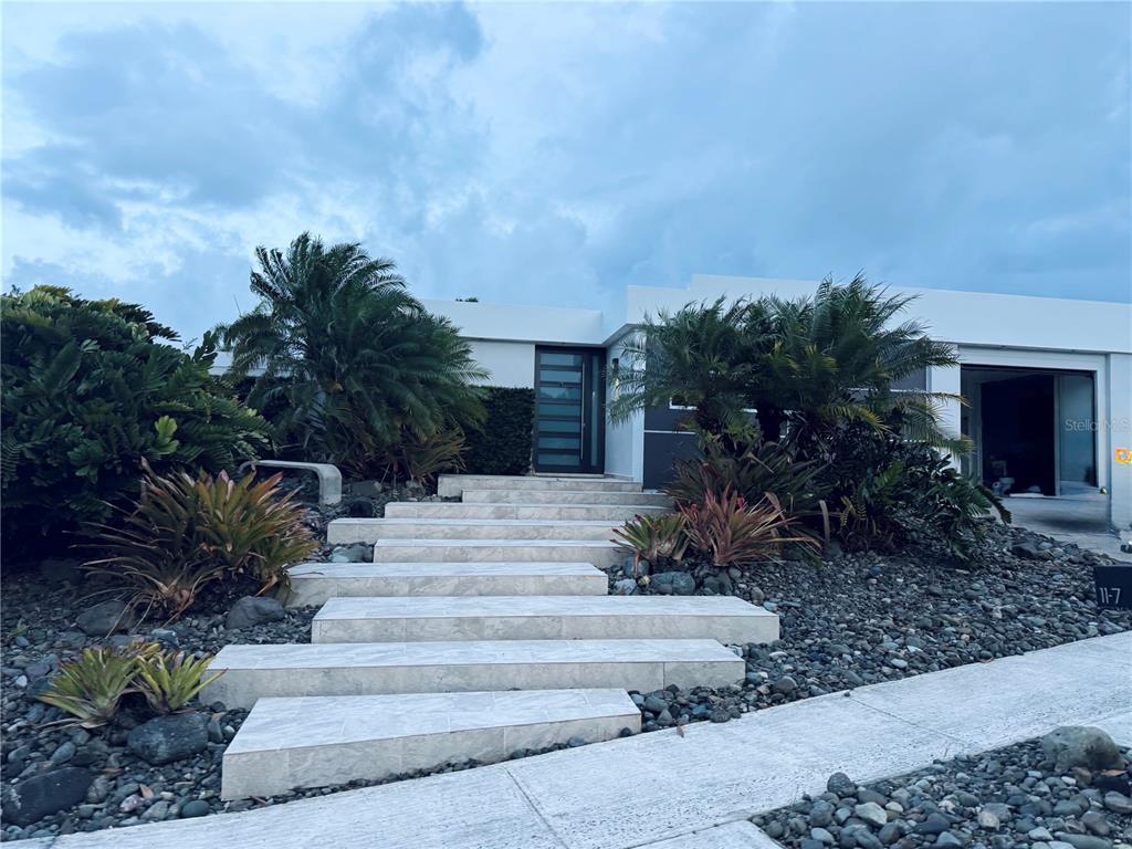 A modern house exterior features a stone staircase leading to a dark front door — 7 ALTURAS DE TORRIMAR UNIT 11-7, GUAYNABO, PR
