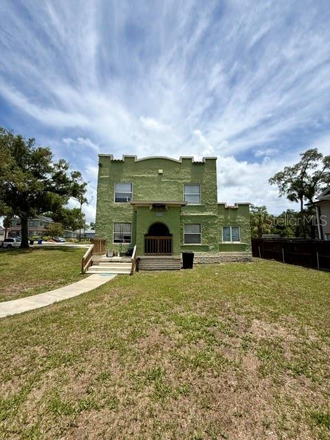 A green, two-story stucco building features a central arched entryway and a front walkway — 2314 TRELAIN DRIVE S, ST PETERSBURG, FL
