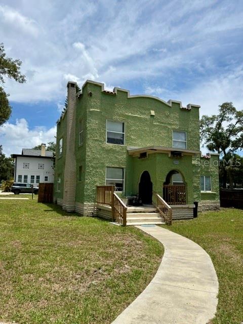 A two-story, green stucco house with a crenelated roofline and a front porch — 2314 TRELAIN DRIVE S, ST PETERSBURG, FL