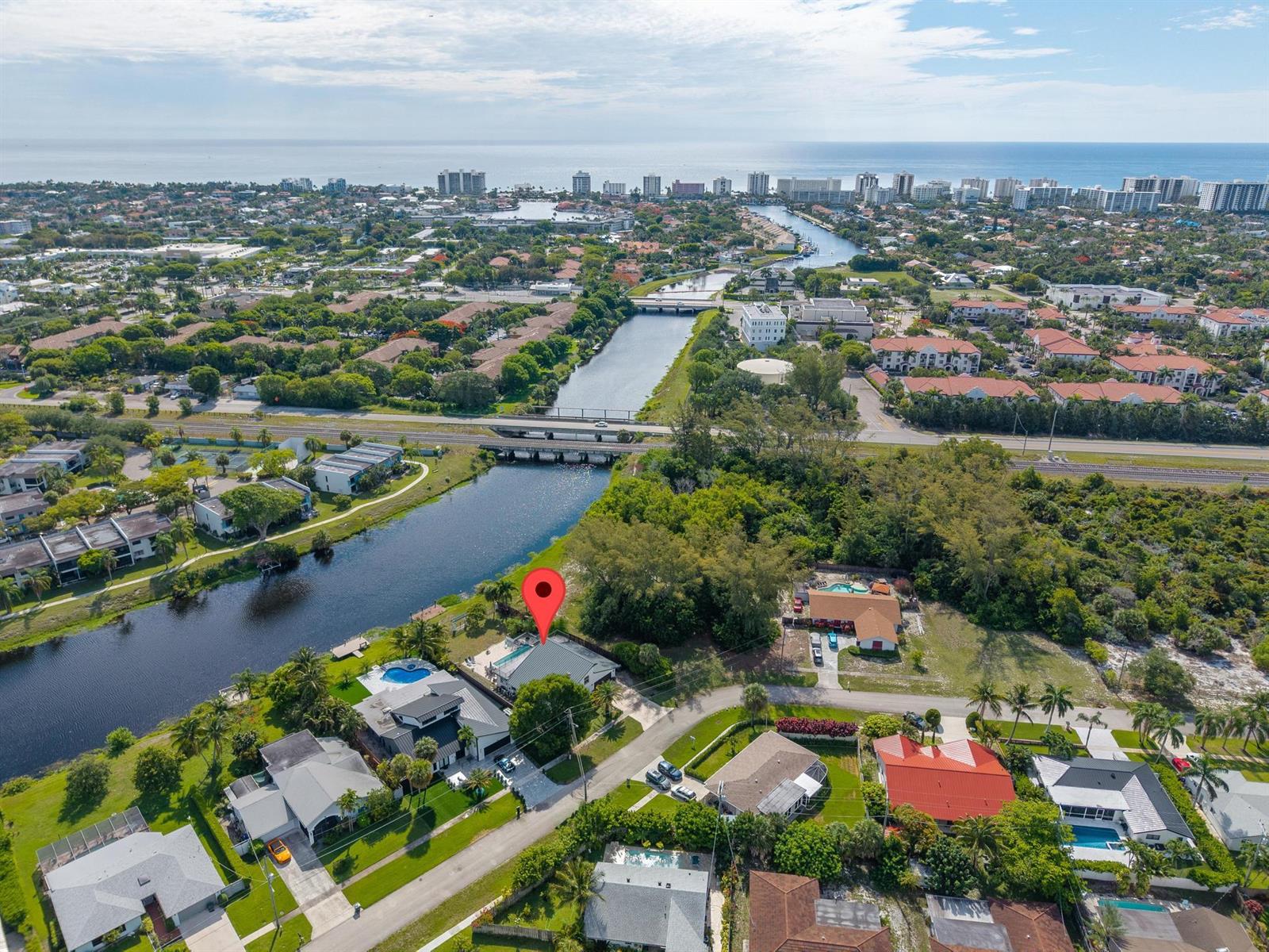 An aerial view shows a waterfront house with a pool and a red location pin — 33 Oregon Lane, Boca Raton FL 33487, BOCA RATON, FL
