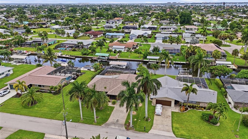 An aerial view of suburban waterfront homes with swimming pools and palm trees in Florida — 418 AVALON DRIVE, CAPE CORAL, FL