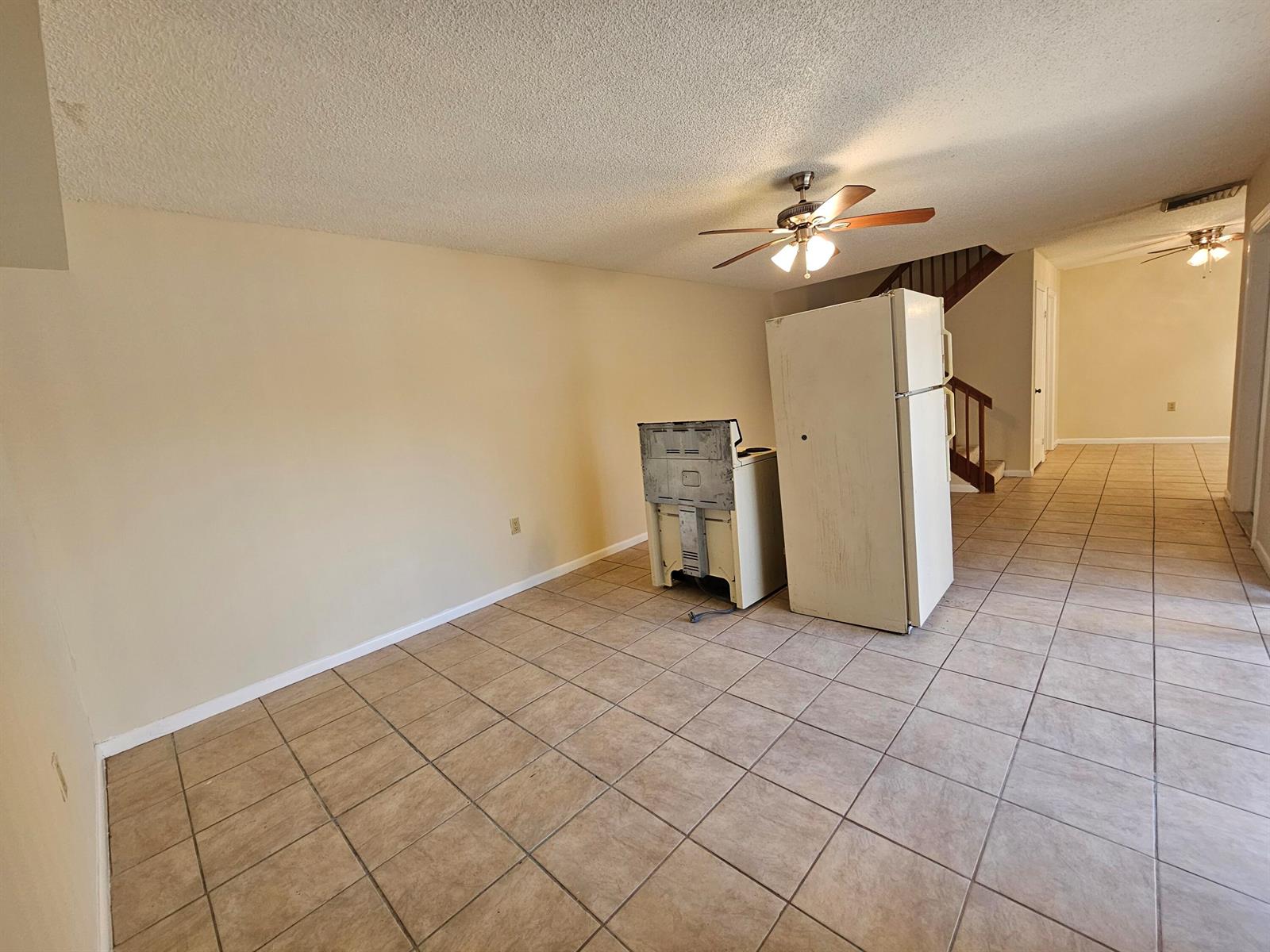 An empty room with tile flooring, a ceiling fan, and a refrigerator and stove — 5152 51st Way, West Palm Beach FL 33409, WEST PALM BEACH, FL