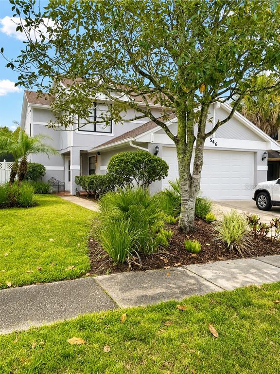 A two-story house with gray siding, a white garage door, and a front yard — 546 CIDERMILL PL, LAKE MARY, FL